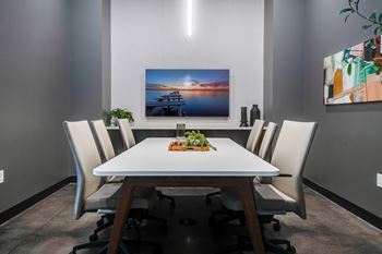 A dining room with a white table and white chairs